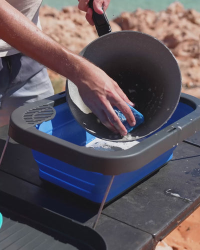Washing a large pot in the Flexi Sink at camp